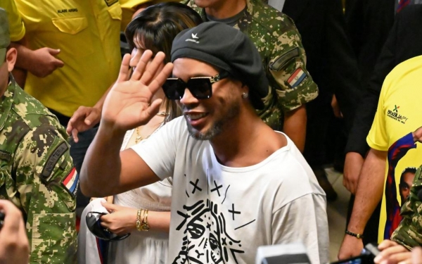 O ex-jogador Ronaldinho Gaúcho acena ao chegar ao Aeroporto Internacional Silvio Pettirossi, em Luque, perto de Assunção — Foto: Norberto Duarte / AFP Photo