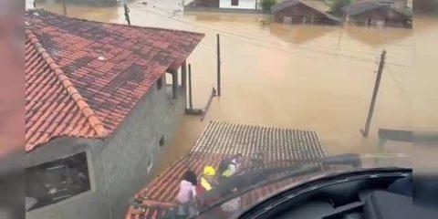 Ilhados pela água das chuvas, moradores sobem em telhados das casas e são resgatados em SC. Foto: Reprodução.