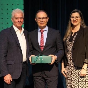 O presidente e a Diretora de Operações da Sicredi Progresso, Cirio Kunzler e Carina Vargas, entregam lembrança ao palestrante da noite, Carlos Cogo. Foto: Divulgação.