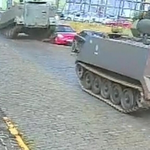 Na contramão, tanque do Exército passa por cima de lateral de carro estacionado em Ponta Grossa — Foto: Reprodução  Vídeos 